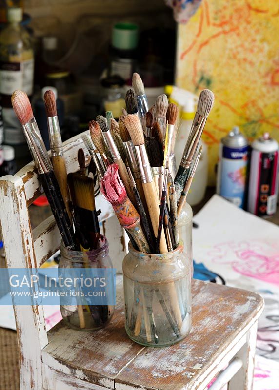Collection de pinceaux sur une chaise dans un atelier d'artiste