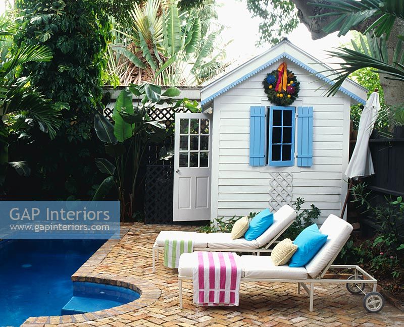 Chaises longues et pavillon d'été dans un jardin tropical