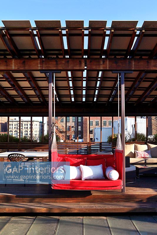 Terrasse sur le toit moderne avec siège de balançoire rouge