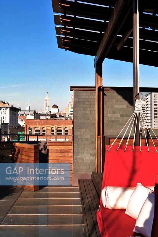 Terrasse sur le toit moderne avec siège de balançoire rouge
