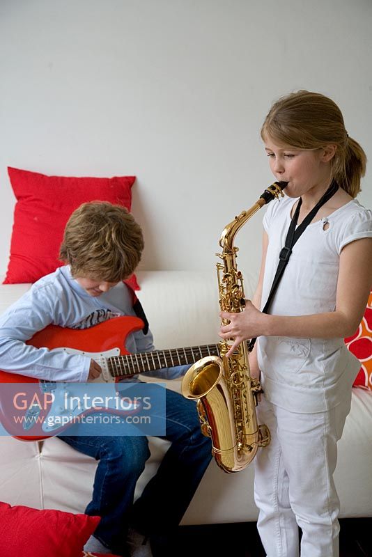 Fille jouant du saxophone et garçon jouant de la guitare