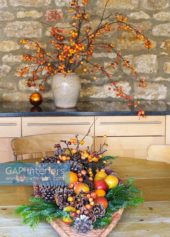 Arrangement de Noël de pommes de pin, fruits et baies sur table en bois