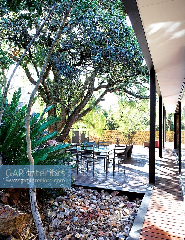 Jardin tropical avec terrasse en bois par maison moderniste