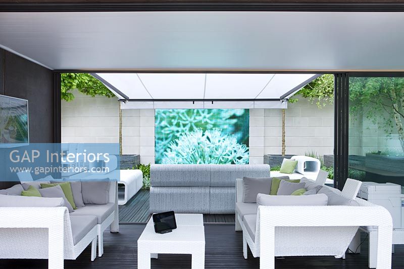 Salon contemporain sous un auvent résistant aux intempéries avec écran vidéo projeté sur le mur - RHS Chelsea Flower Show 2012