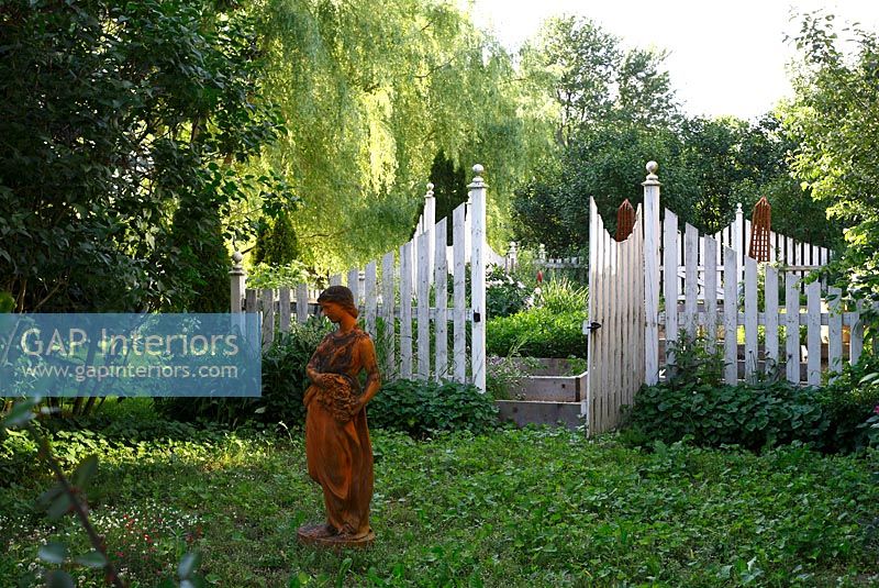 Statue classique debout dans une zone ombragée de jardin