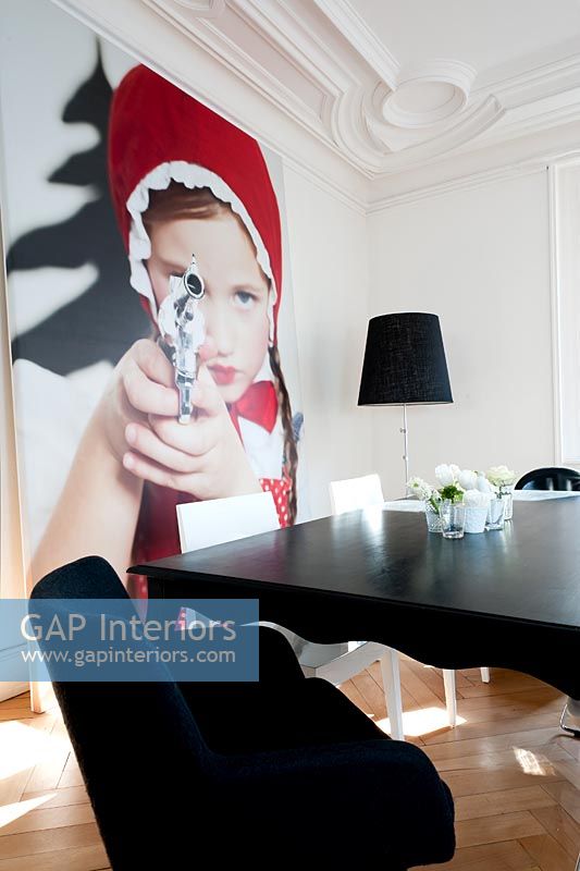 Salle à manger contemporaine avec photo du 'Petit Chaperon Rouge visant le revolver' par Sandra Seckinger