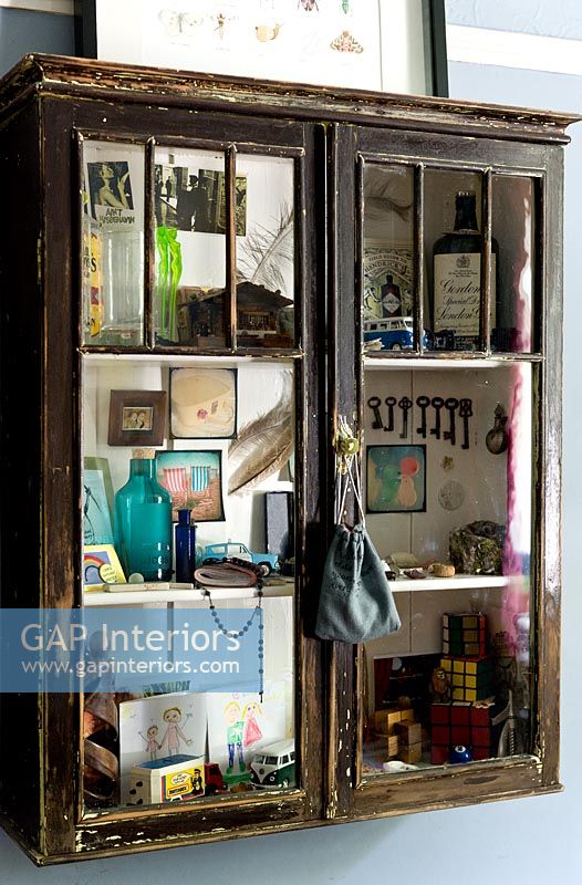 Ornements et accessoires vintage affichés dans une armoire en bois