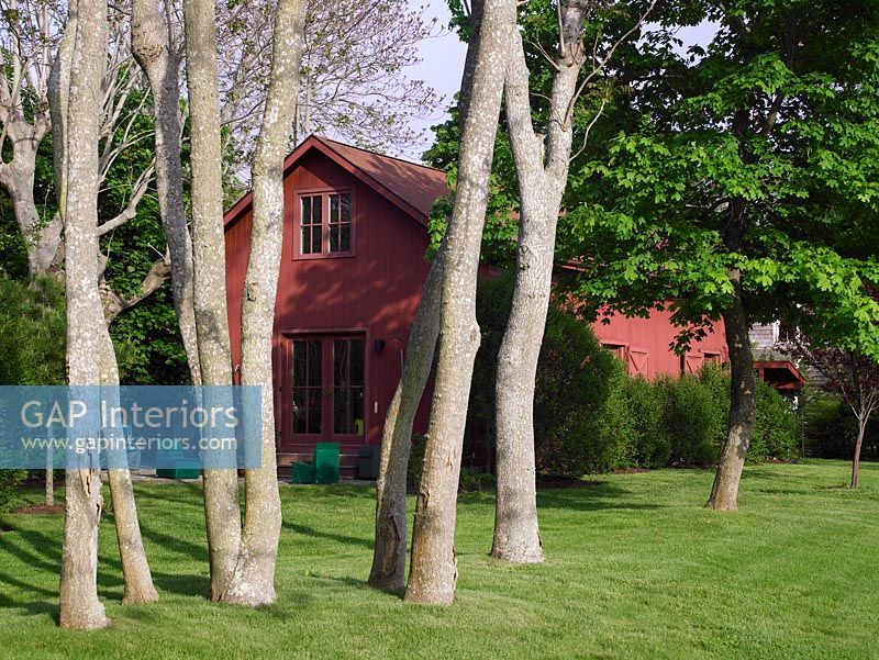 Maison rouge et jardin boisé