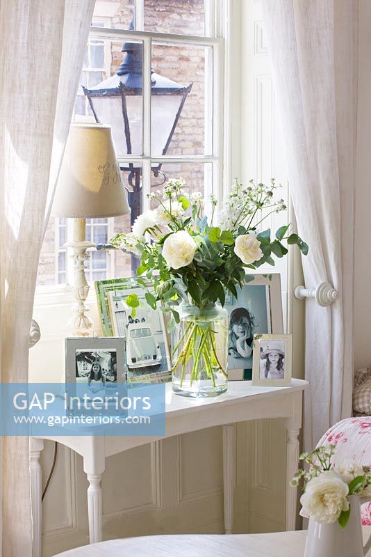 Table basse avec affichage de photos et de roses dans un vase