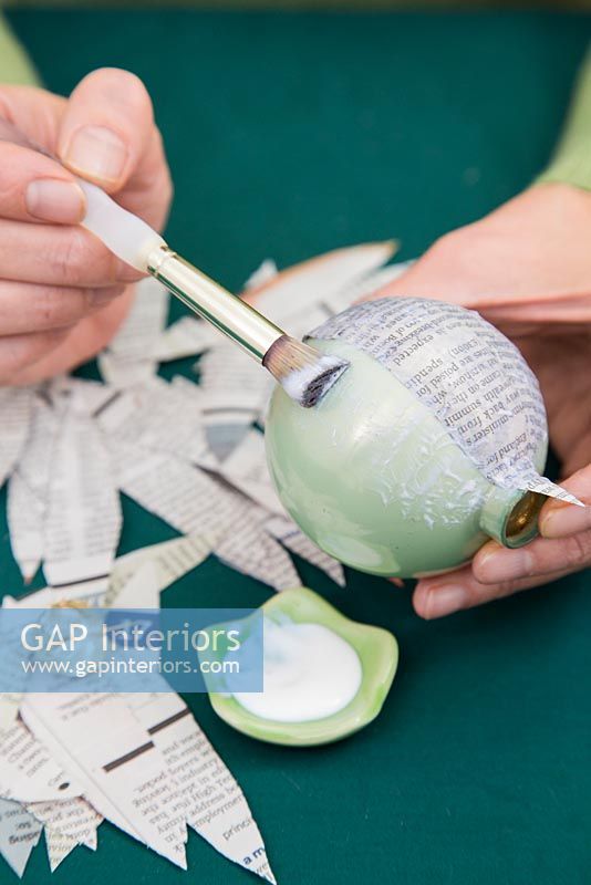 Créez une simple boule de Noël en utilisant du papier journal - ajoutez de la colle à la boule