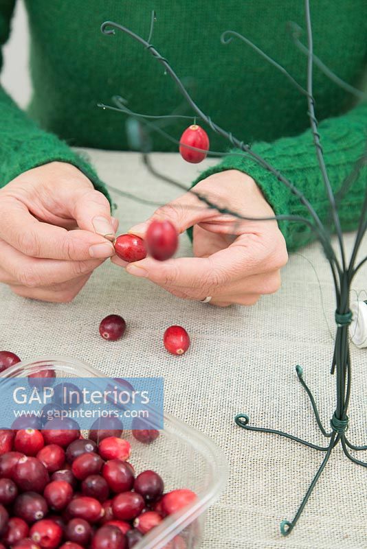 Utilisation de coton et de fil de jardin pour créer un arbre de Noël - Ajout de petits crochets aux canneberges fraîches