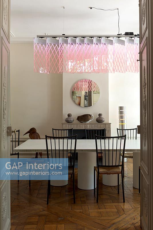 Salle à manger moderne avec mobilier design et suspension rose par Johanna Grawunder