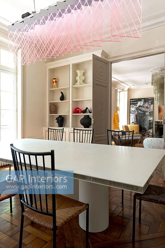 Salle à manger moderne avec mobilier design et suspension rose par Johanna Grawunder
