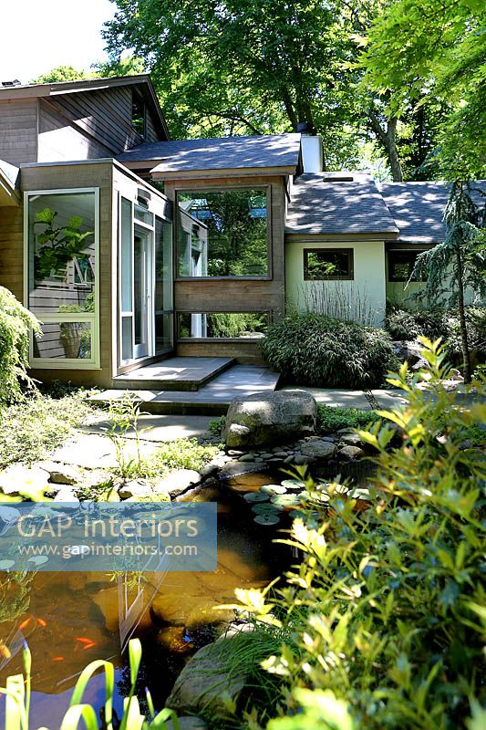 Maison moderne et jardin avec étang
