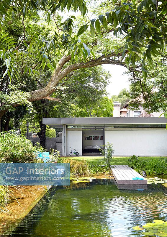 Maison moderniste et jardin avec étang