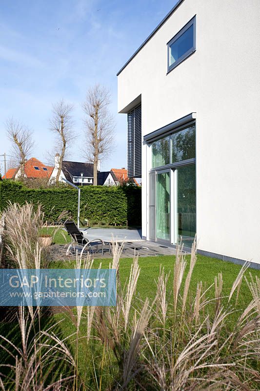 Maison contemporaine et jardin avec des herbes ornementales