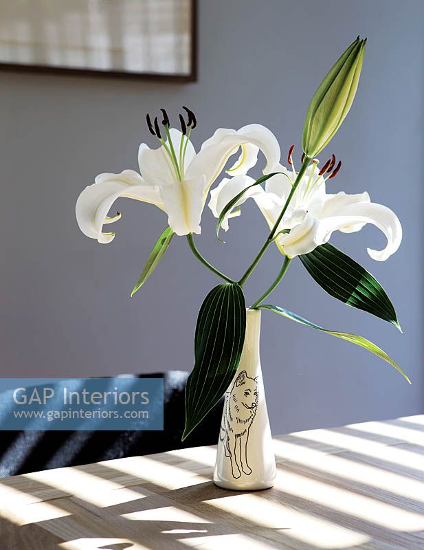 Vase de Lys blancs sur table à manger