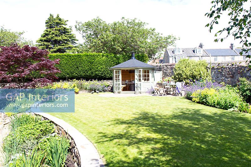 Jardin avec pavillon d'été et bordures colorées