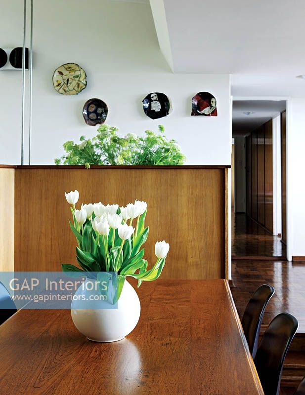 Vase de tulipes blanches sur table à manger en bois