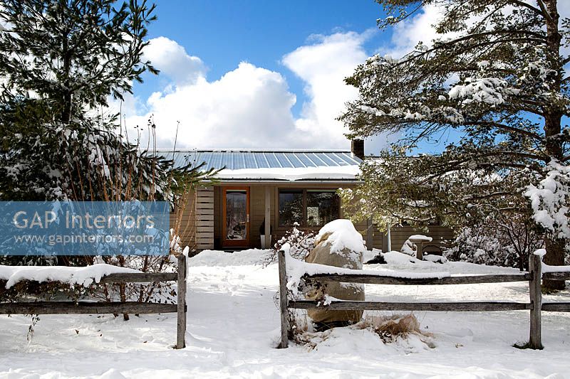 Maison de style ranch en bois dans la neige