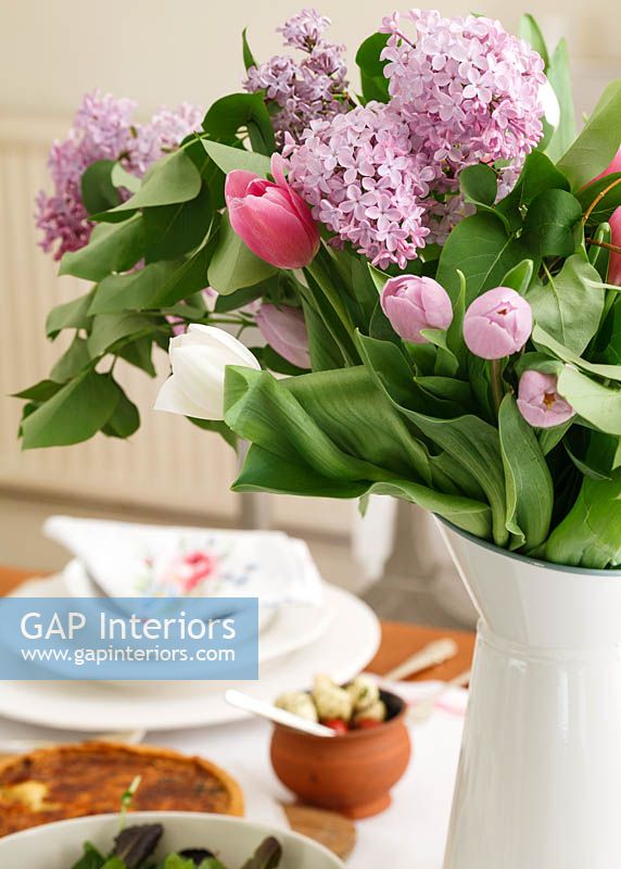 Cruche de tulipes et de fleurs de jacinthe sur table à manger