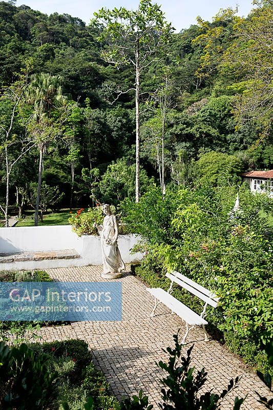 Jardin tropical avec zone pavée et statues