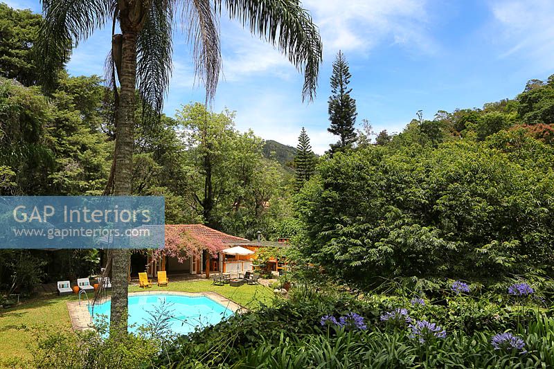 Jardin tropical avec pavillon d'été et piscine