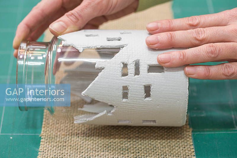 Fabrication de lanternes en argile - Roulez doucement le bocal en verre le long d'un morceau de toile de jute pour ajouter de la texture à l'argile