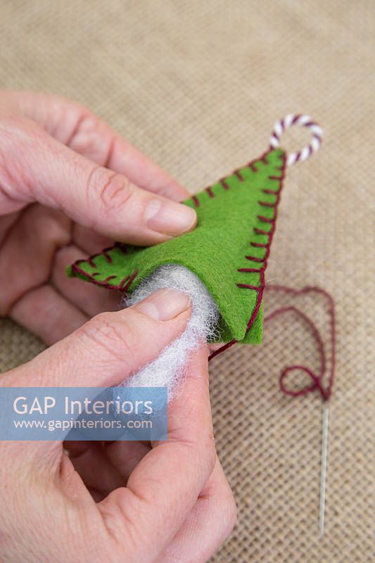 Faire des décorations de Noël en feutre cousu - Insérez le rembourrage en laine dans le feutre