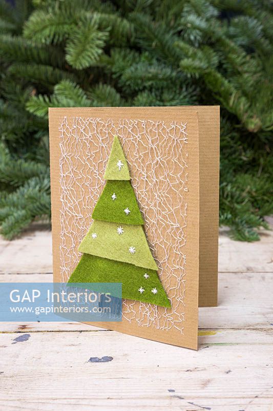 Faire des cartes d'arbre de Noël en feutre - Une carte de Noël faite à la main avec un arbre de Noël en couches sur un fond blanc