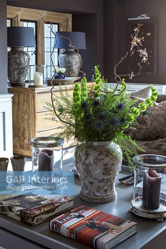 Cloches d'Irlande et fleurs de houx de mer dans un vase à motifs