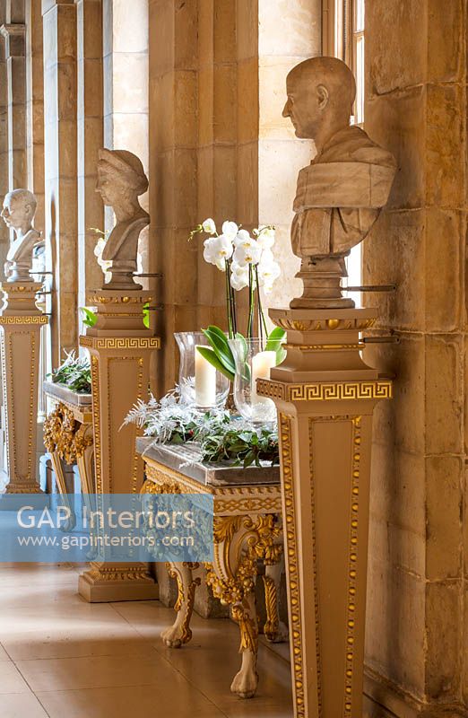 Décorations de Noël avec des orchidées blanches, des bougies et des couronnes dans le passage antique, Castle Howard