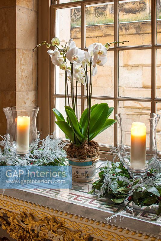Décorations de Noël avec des orchidées blanches, des bougies et des couronnes dans le passage antique, Castle Howard