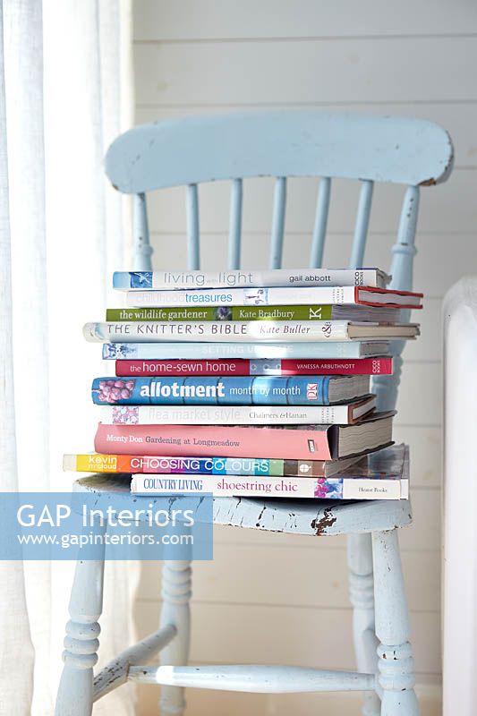 Pile de livres sur une chaise bleue