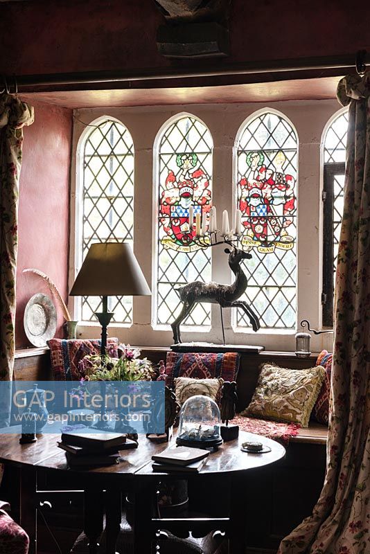 Siège de fenêtre avec coussins représentant des souches anciennes et des vitraux - Cothay Manor