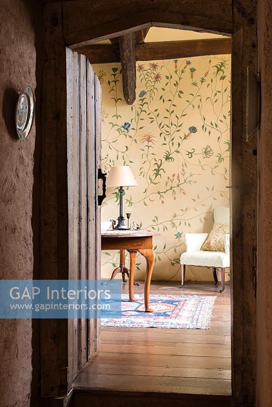 Vue du couloir dans la chambre avec un motif floral peint à la main sur les murs par Arabella Arkwright - Cothay Manor