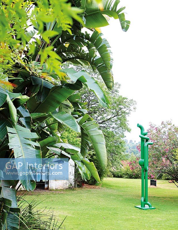 Jardin avec plantation tropicale et sculpture moderne
