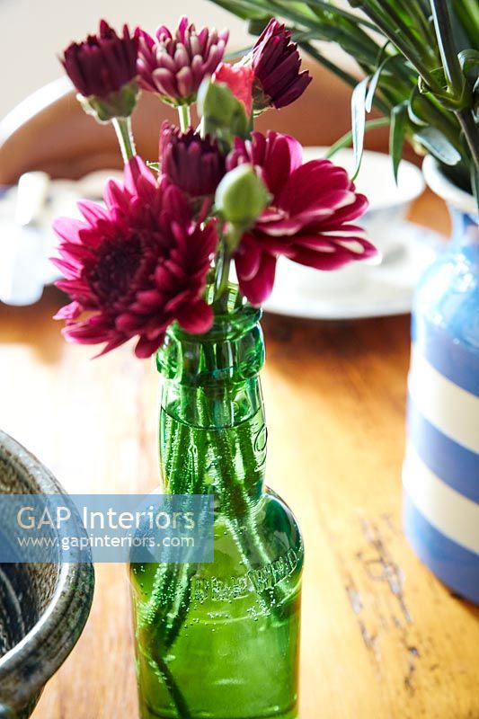 Bouteille de fleurs de chrysanthème sur table de cuisine