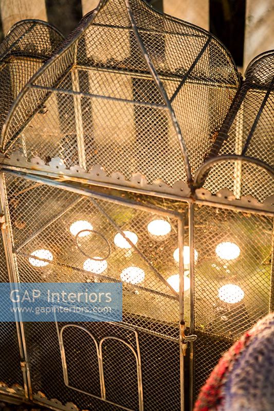 Détail de cage à oiseaux en métal avec des bougies chauffe-plat