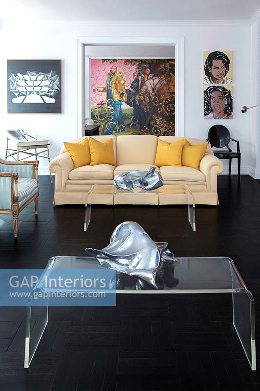 Tables basses en plexiglas dans un salon éclectique avec des illustrations colorées