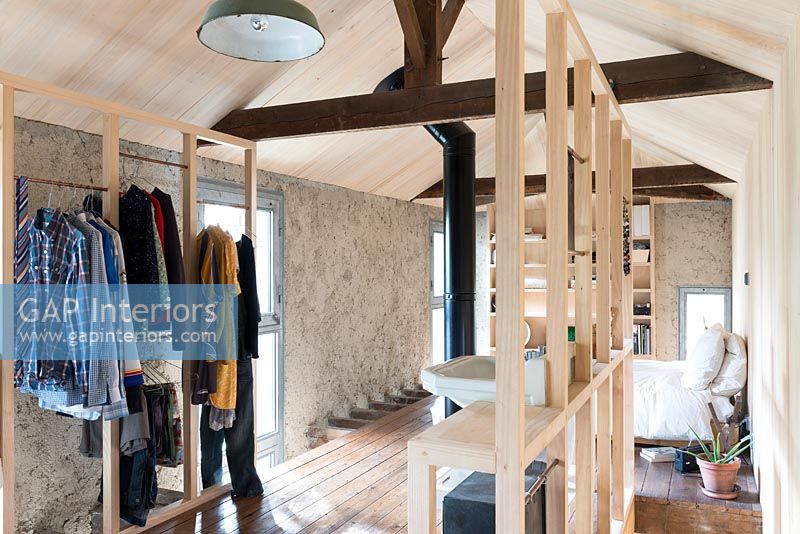 Salle de bain à ossature bois dans une chambre ouverte avec cheminée apparente