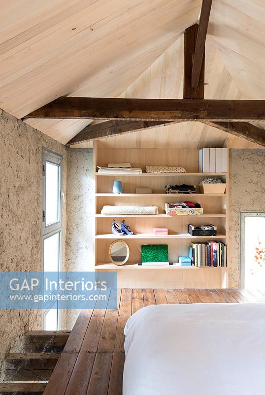 Étagères dans une chambre en bois moderne avec poutres apparentes et plafonds en bois