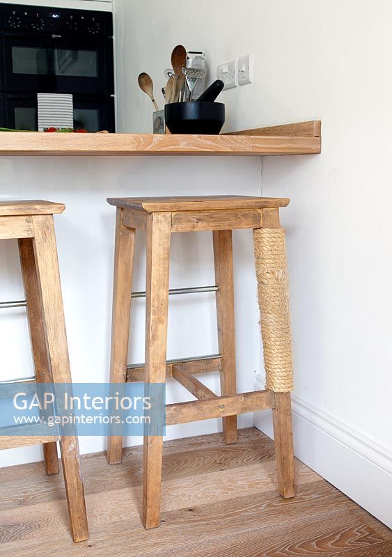 Tabourets de bar en bois avec un griffoir pour chat sur une jambe de tabouret