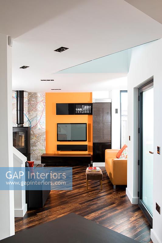 Télévision orange et poêle à bois dans le salon moderne