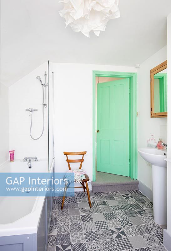 Salle de bain moderne avec porte peinte en vert menthe et carrelage à motifs