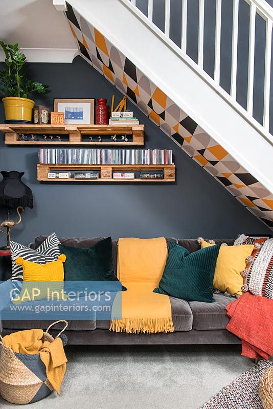 Canapé sous escalier dans un salon ouvert moderne et coloré