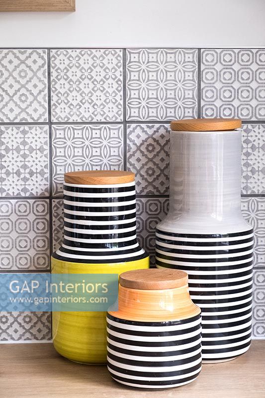 Pots de rangement en céramique dans la cuisine avec des carreaux gris à motifs