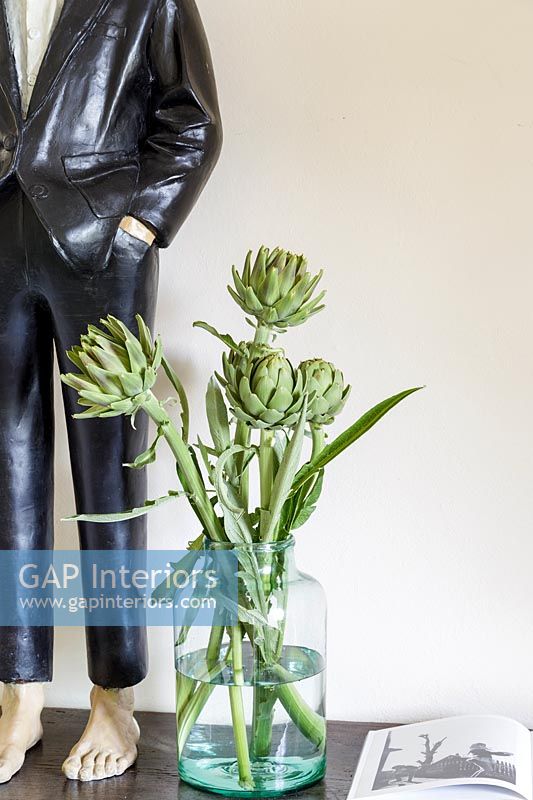 Artichauts dans un vase à côté de la sculpture