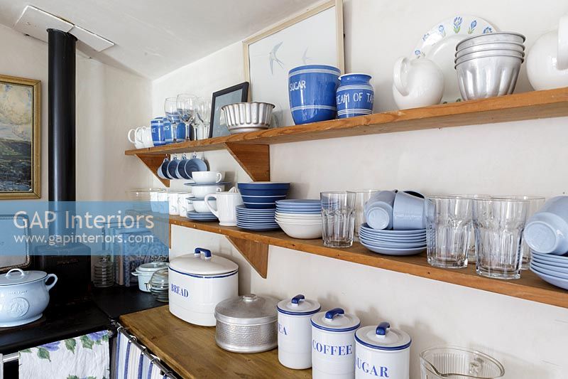 Vaisselle bleue et blanche sur une étagère en bois dans la cuisine du chalet
