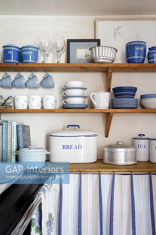 Vaisselle bleue et blanche sur une étagère en bois dans la cuisine du chalet